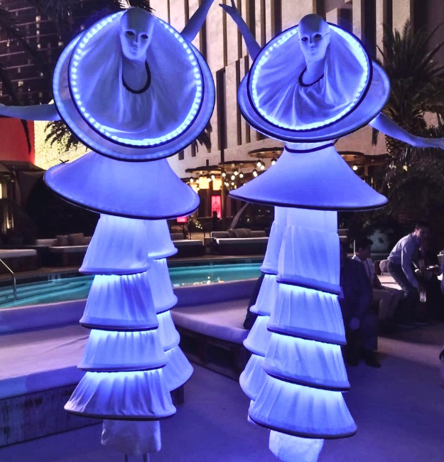 Two LED stilt walkers in Arizona dressed in white costuming with large LED hoops strolling private outdoor party | Altus Entertainment