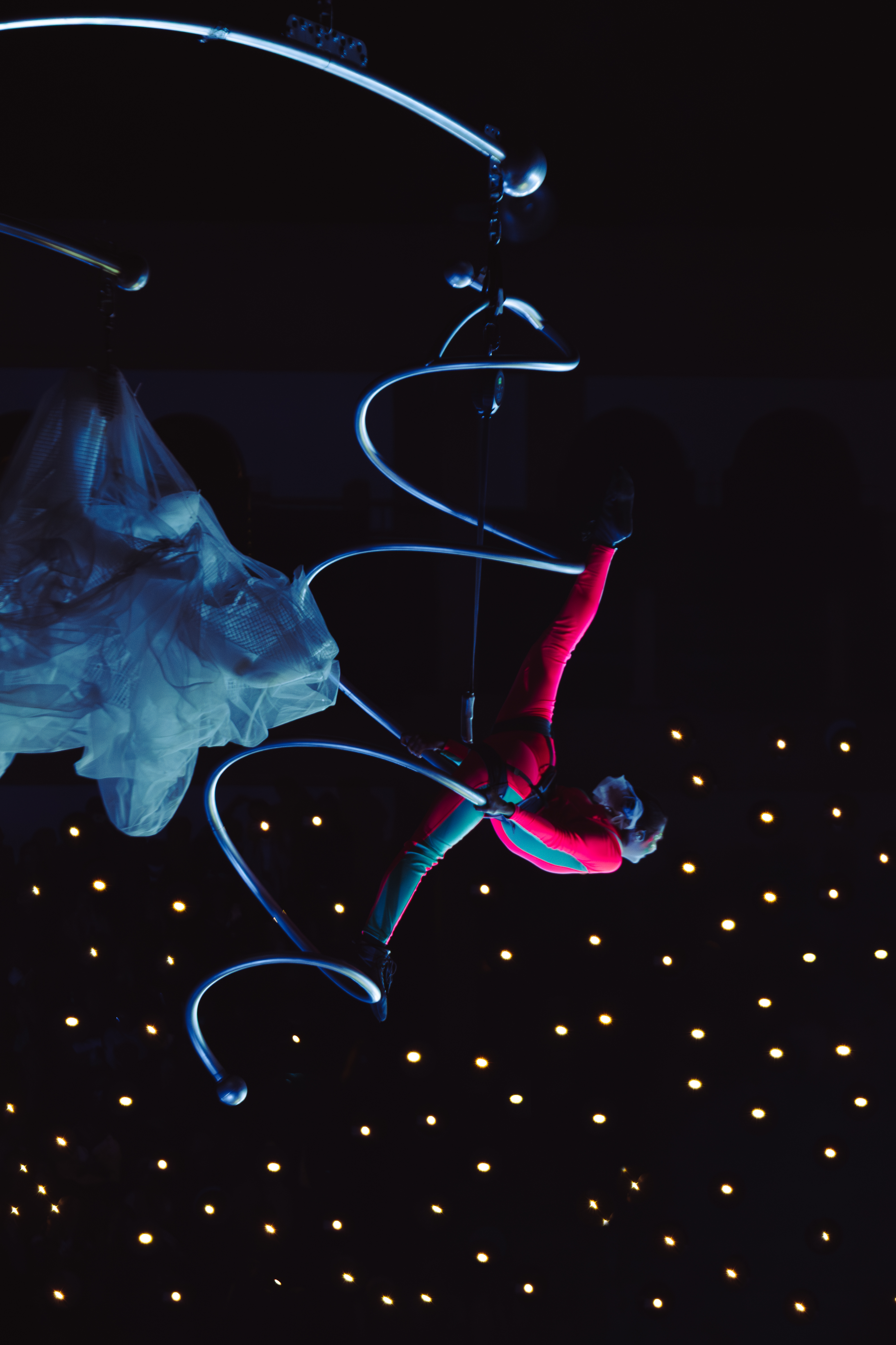 Professional picture of spiral aerial hoop hanging from rig while performing the spits in air at private event | Altus Entertainment